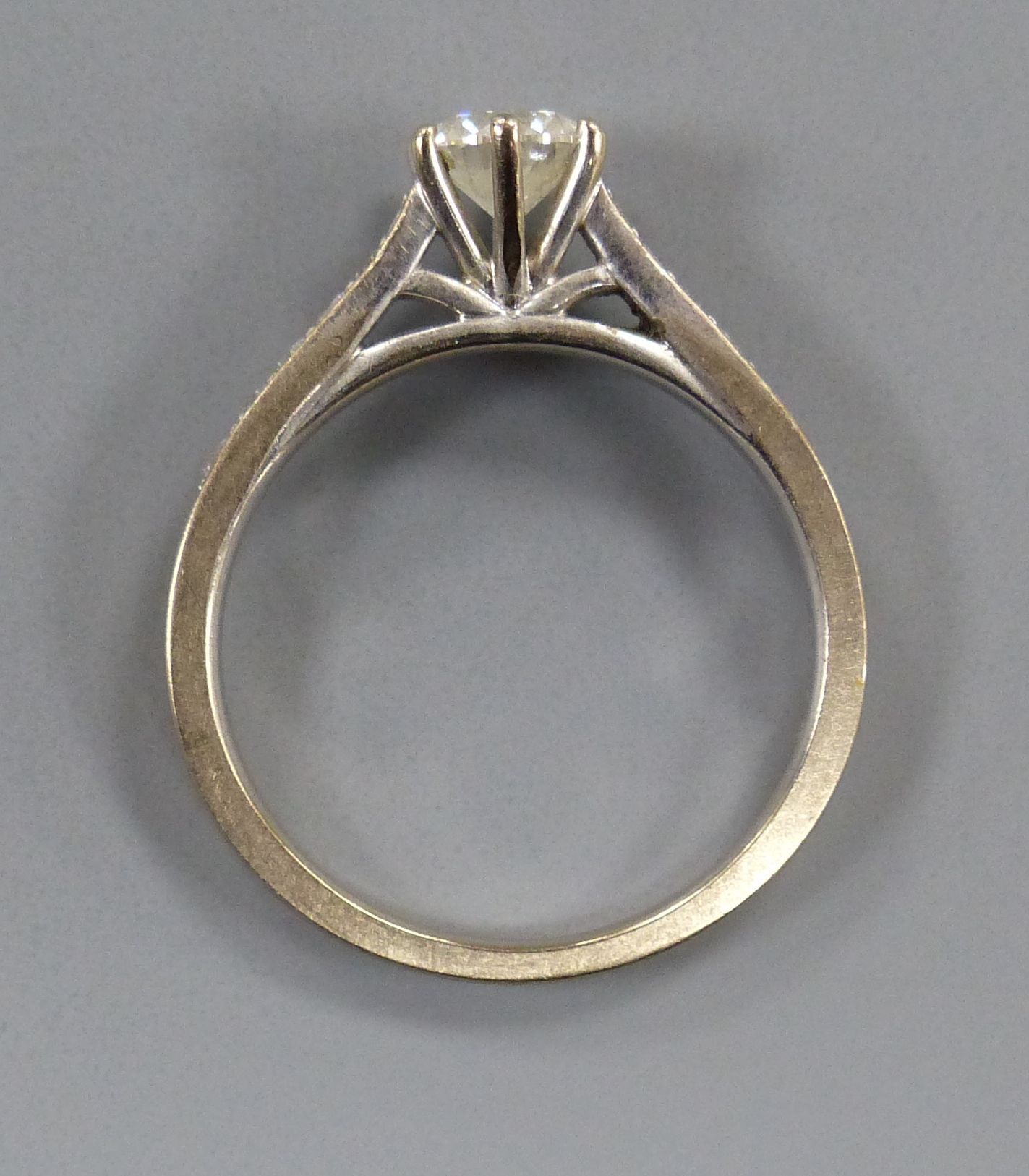 A diamond solitaire ring with diamond-set shoulders, 18ct white gold setting, size L, gross 3.2 grams.
